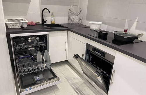 Saint-Brice-sous-Foret Apartment | L'appartement dispose d'un lit, d'un canapé-lit et d'une cuisine avec un réfrigérateur